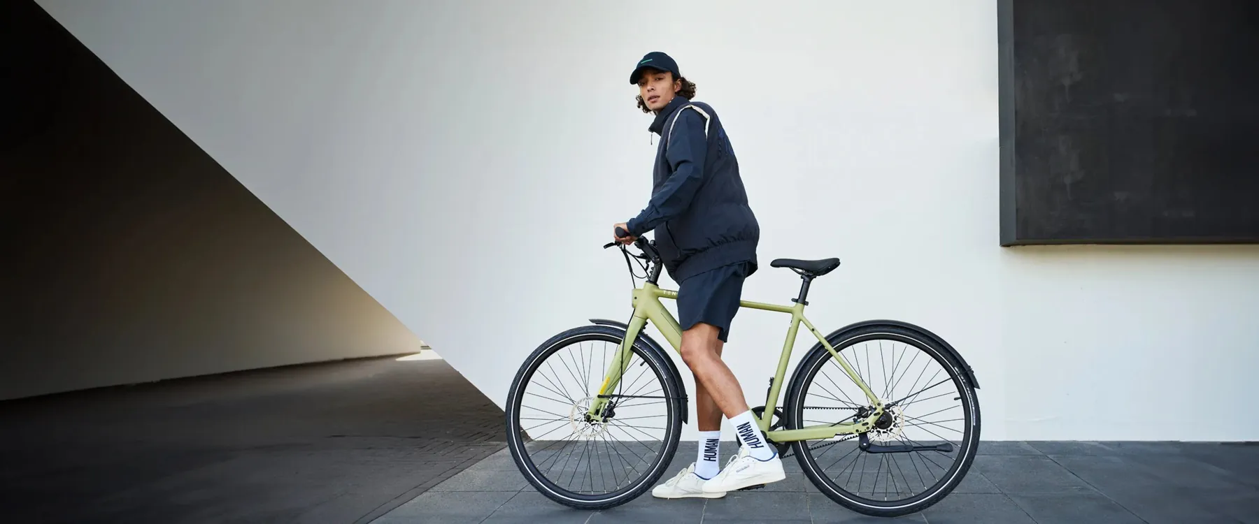 Cycliste souriant avec son vélo électrique en ville